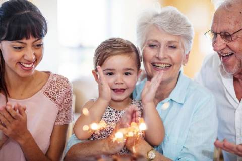 Little girl lwatching sparklers on a birthday cake, sitting on grandmother s lap model released Symbolfoto property released  ZEF14250