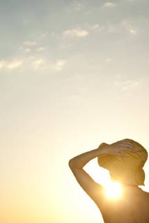 IMAGO Creative, Jahreszeit Sommer, Sonnenschutz Woman outdoors silhouetted against setting sun  Copyright: FrédéricxCirou B67486609