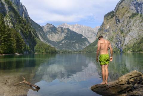 Junger Mann in Badehose steht auf einem Stein im Obersee, Bergsee, Berglandschaft, hinten Watzmannmassiv, Salet am Königssee, Nationalpark Berchtesgaden, Berchtesgadener Land, Oberbayern, Bayern, Deutschland, Europa Copyright: imageBROKER/ValentinxWolf ibxvfw04749870.jpg