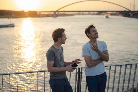 Two friends meeting at sunset, spending the evening talking model released Symbolfoto GUSF01206