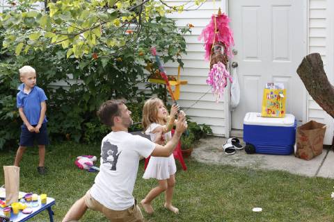 Mid adult father playing with little daughter during birthday party in front or back yard, Oak Park IL United States model released Symbolfoto Copyright: BethxRooney ROBE000567