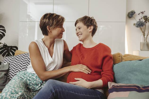 Happy lesbian couple touching belly of the expectant mother model released Symbolfoto property released MFF04440