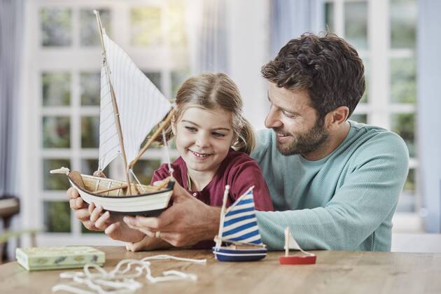 Happy father and daughter playing with model boat at home model released Symbolfoto property released  RORF01396