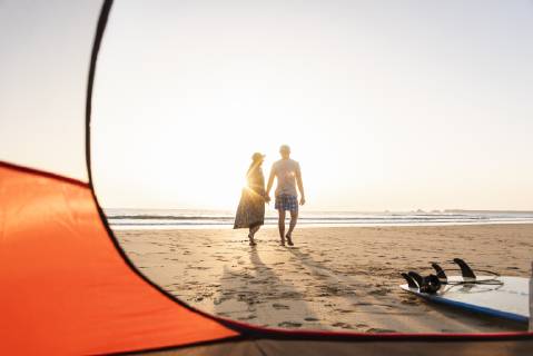 Romantic couple camping on the beach, doing a beach stroll at sunset model released Symbolfoto  UUF15148