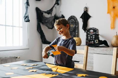 Smiling little boy cutting out for Halloween decoration at home model released Symbolfoto property released  JRFF01886