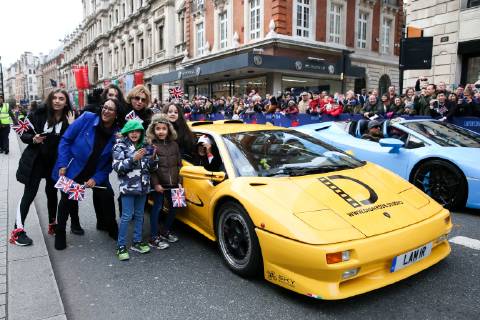 January 1, 2019 - London, United Kingdom - People seen standing next to a Lamborghini during the parade..Over half a million spectators lined up the 2.2 mile route from Piccadilly Circus to Parliament Square as more than 8,000 performers from 26 countries participated in the 33rd London™s New Year s Day Parade. London United Kingdom - ZUMAs197 20190101_zaa_s197_055 Copyright: xDinendraxHariax