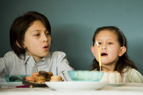 Girl blowing out candle on birthday cake  Copyright: FrédéricxCirou B09017733