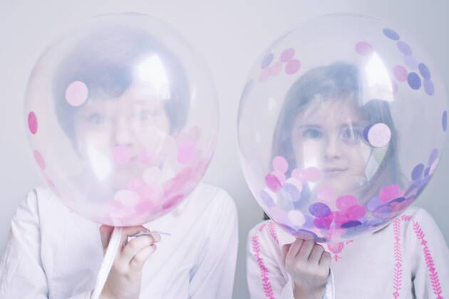 Children hiding behind transparent balloons  Copyright: Anne-SophiexBost B40089521