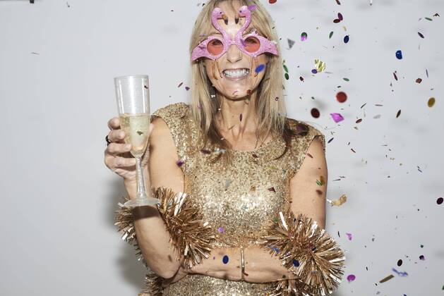 Senior woman wearing golden dress and flmingo shaped glasses, celebtraing New Year s Eve model released Symbolfoto property released  IGGF00691