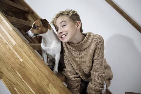 Portrait of grinning boy and his Jack Russel Terrier on stairs at home model released Symbolfoto property released  KMKF00650
