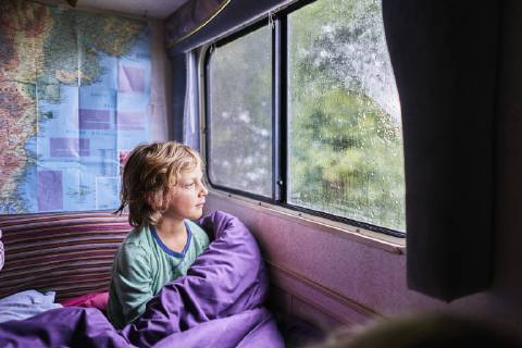 Boy in pyjama looking out of window of a camper model released Symbolfoto property released SSCF00162