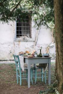 Laid garden table with candles next to a cottage  ALBF00718