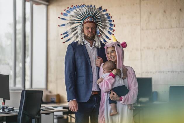 Man and woman, dressed as Indian and unicorn, standing in office, woman holding baby in her arms model released Symbolfoto property released  RIBF00869