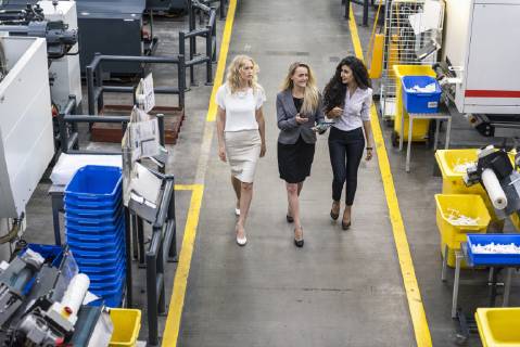 Three women with tablet walking and talking in factory shop floor model released Symbolfoto property released  DIGF05291