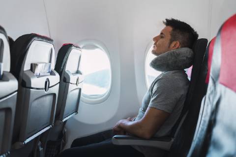 Man sleeping with neck pillow in airplane model released Symbolfoto KKAF02468