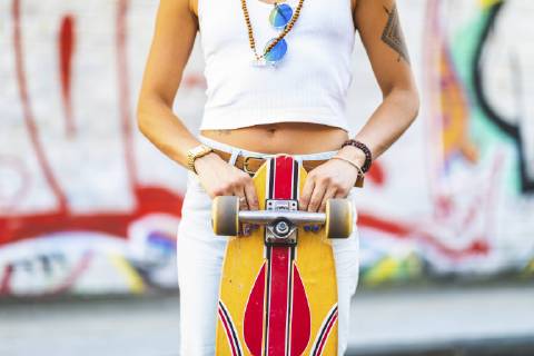 Close-up of young woman with skateboard at graffiti wall model released Symbolfoto  WPEF00783