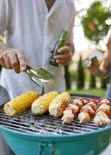 Corn cob and meat skewer on grill at barbecue in garden model released Symbolfoto property released  ZEDF01598