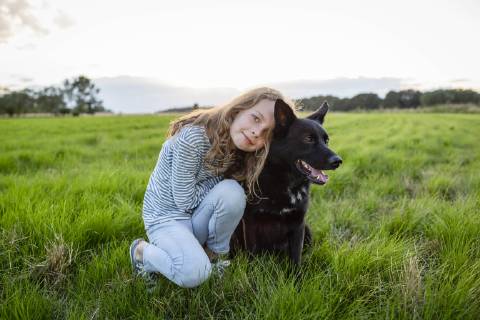 Girl with a dog sitting on a field model released Symbolfoto property released  OJF00273