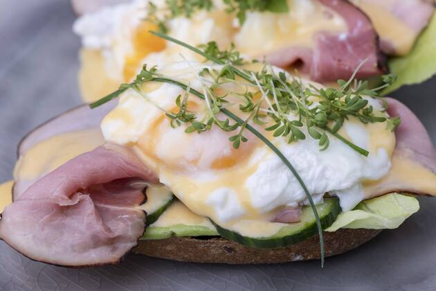 Nahaufnahme von einem gekochten Ei mit Kaffee - eggs benedict