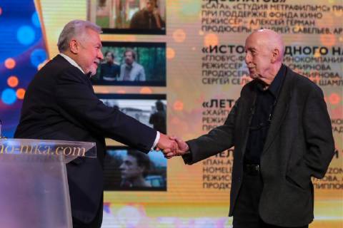 MOSCOW, RUSSIA â€“ MARCH 30, 2019: Nika founder and artistic director Yuli Gusman (L) shakes hands with director Otar Iosseliani, the winner of a special prize Honour and Dignity , at the 32nd Nika Film Award Ceremony. Vyacheslav Prokofyev TASS  TS0A6774