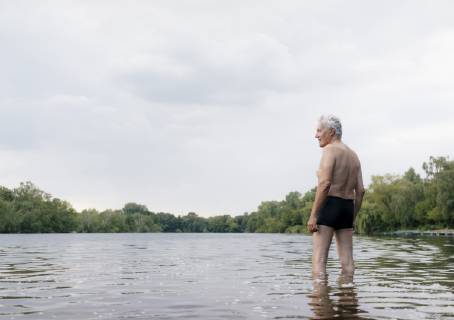 Senior man standing in a lake model released Symbolfoto  GUSF01790