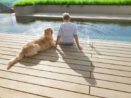 Senior woman sitting with dog at the poolside model released Symbolfoto property released  LAF02209
