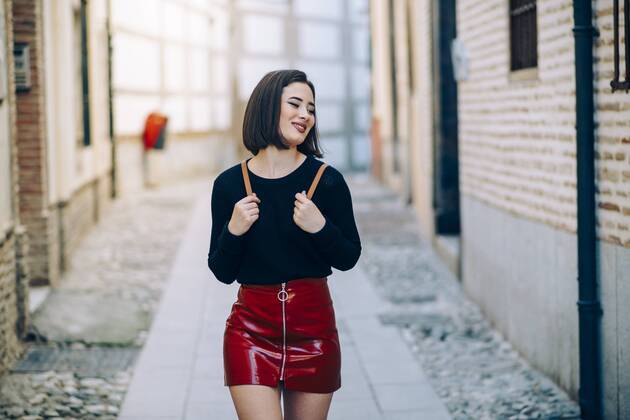 Portrait of young woman wearing red patent leather skirt with zipper model released Symbolfoto  JSMF00741
