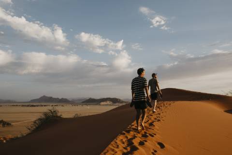 IMAGO Creative: Sommer, Abendspaziergang Namibia, Namib desert, Namib-Naukluft National Park, Sossusvlei, two men walking on Elim Dune at sunset model released Symbolfoto  LHPF00254