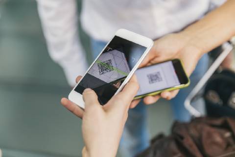 Airline employee scanning QR codes of passengers with smartphone at the airport model released Symbolfoto property released MFF04729