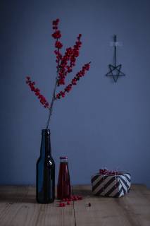 IMAGO Creative: Weihnachten, DIY, Geschenke verpacken - Nachhaltigkeit Twig of holly in glass bottle and wrapped present OJF00335