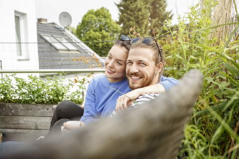 Young couple relaxing on their balcony, sitting on couch model released Symbolfoto property released  PESF01161