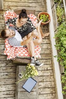 Young couple sitting on their balcony in summer, holding hands model released Symbolfoto property released  PESF01185