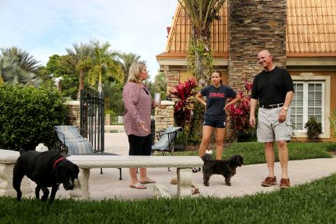 March 31, 2019 - Palm Harbor, Florida, U.S. - DOUGLAS R. CLIFFORD Times.Pasco Circuit judge Lauralee Westine, left, Lauren Gaultieri, 13, and Pinellas County Sheriff Bob Gualtieri visit while giving their dogs McDuff and Graham a bathroom break outside their home in Palm Harbor (3 31 19) Palm Harbor U.S. - ZUMAs70_ 20190331_zan_s70_037 Copyright: xDouglasxR.xCliffordx