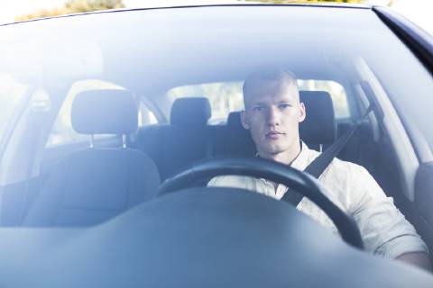 Young man driving car model released Symbolfoto ABZF02247