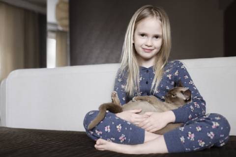 Portrait of smiling little girl wearing pyjama with floral design holding cat in her arms model released Symbolfoto property released  EYAF00076