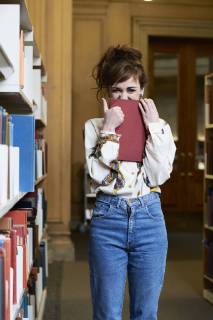 Female student reading book in a public library model released Symbolfoto  IGGF01053