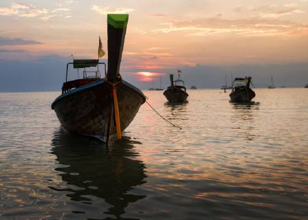 Thailand, Krabi, Railay beach, long-tail boats floating on water at sunset  ALRF01177