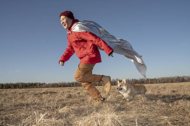 Boy dressed up as superhero running with dog in steppe landscape model released Symbolfoto property released  VPIF01235