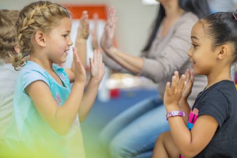 Happy children and pre-school teacher clapping hands in kindergarten model released Symbolfoto property released  ZEF15443