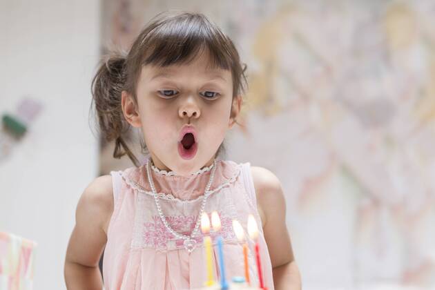 Portrait of little girl blowing out burning candles on her birthday cake model released Symbolfoto  DRF01741