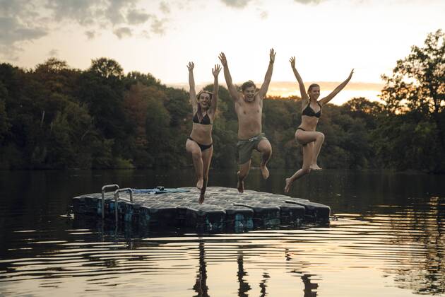Friends having fun at the lake, jumping from bathing platform model released Symbolfoto property released  GUSF02368