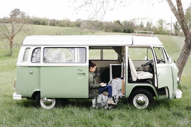 Young woman sitting in her camper, writing in a notebook model released Symbolfoto property released  HMEF00442
