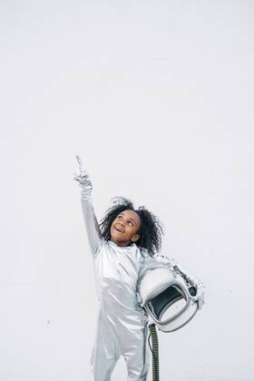 Portrait of smiling little girl wearing space suit in front of white background looking up model released Symbolfoto  JCMF00066