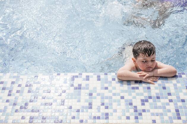 Little boy relaxing at poolside model released Symbolfoto  LJF00033