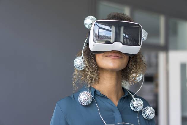 Creative Highlights Symbolfoto Smiling young woman with chain of lights using Virtual Reality Glasses model released Symbolfoto property released  MOEF02379