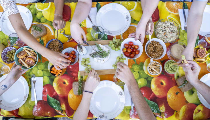 Healthy vegetarian meal on top of colorful table with friends, from above model released Symbolfoto  AFVF03970