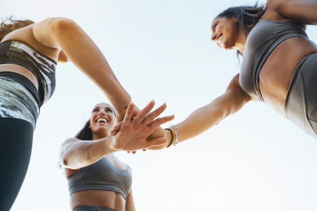 Three happy sporty women stacking their hands after doing sports model released Symbolfoto  JCMF00204