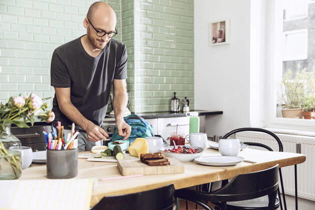 IMAGO Creative: Gesellschaft, Schule, Schulanfang Man in a kitchen packing snacks for lunch break model released Symbolfoto property released  MCF00280