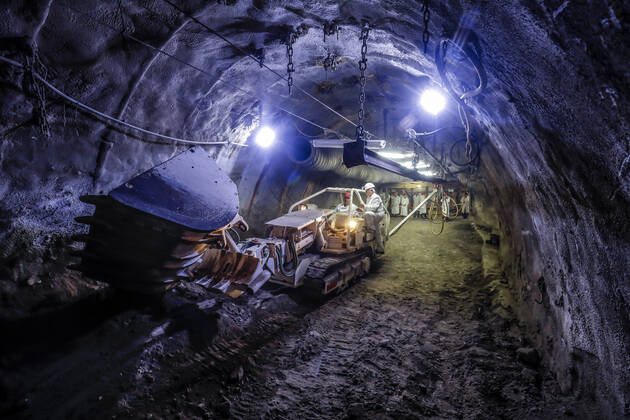 01.10.2019, Recklinghausen, Ruhrgebiet, Nordrhein-Westfalen, Deutschland - Steinkohle-Erlebnisbergwerk Recklinghausen, das Trainingsbergwerk Recklinghausen wird das groesste Besucherbergwerk fuer Steinkohle in Deutschland, Fuehrung einer Besuchergruppe, Besucher koennen an Maschinen und Werkzeugen alles selbst ausprobieren, hier am Raupenbagger. Recklinghausen Nordrhein-Westfalen Deutschland