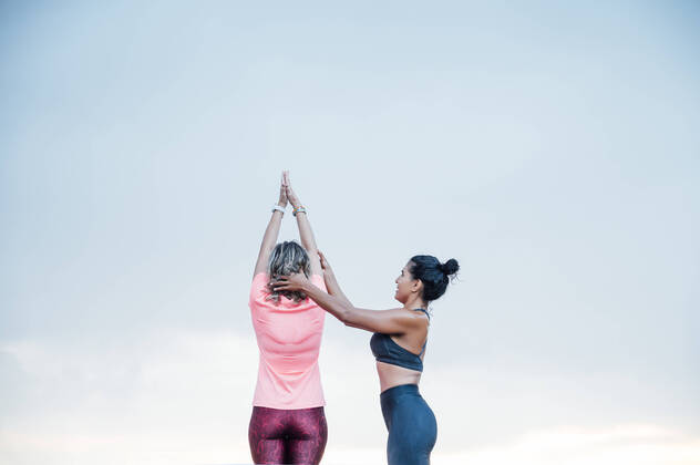 Woman teaching yoga to senior woman model released Symbolfoto  OCMF00732